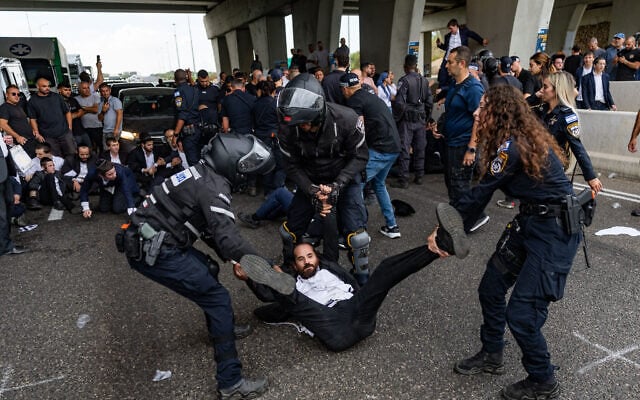 Ultra-Orthodox demonstrators clash with police officers and civilians as they block Route 4 during a protest against the jailing of yeshiva students who failed to comply with an army recruitment order, at the Yavne Interchange October 18, 2026. (Chaim Goldberg/Flash90) Ultra-Orthodox demonstrators clash with police officers and civilians as they block Route 4 during a protest against the jailing of yeshiva students who failed to comply with an army recruitment order, at the Yavne Interchange October 18, 2026. (Chaim Goldberg/Flash90)
