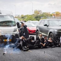 A stun grenade appears to explode next to ultra-Orthodox demonstrators during clashes with police officers and civilians as they blocked Route 4 during a protest against the jailing of yeshiva students who failed to comply with an army recruitment order, at the Yavne Interchange, October 18, 2026. (Chaim Goldberg/Flash90) A stun grenade appears to explode next to ultra-Orthodox demonstrators during clashes with police officers and civilians as they blocked Route 4 during a protest against the jailing of yeshiva students who failed to comply with an army recruitment order, at the Yavne Interchange, October 18, 2026. (Chaim Goldberg/Flash90)