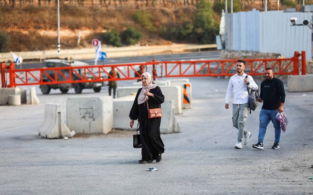 Palestinians walk past a checkpoint at the entrance to the West Bank city of Hebron, which Israeli security forces closed following a deadly shooting attack that killed two Israeli soldiers the previous day, October 24, 2026. (Wisam Hashlamoun/Flash90)