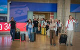 Passengers arrive at Ben Gurion International Airport near Tel Aviv, as activists from various political parties wait to encourage them to vote for their parties in the upcoming election, October 25, 2026. (Rachel Alroey/Flash90)