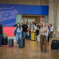 Passengers arrive at Ben Gurion International Airport near Tel Aviv, as activists from various political parties wait to encourage them to vote for their parties in the upcoming election, October 25, 2026. (Rachel Alroey/Flash90)