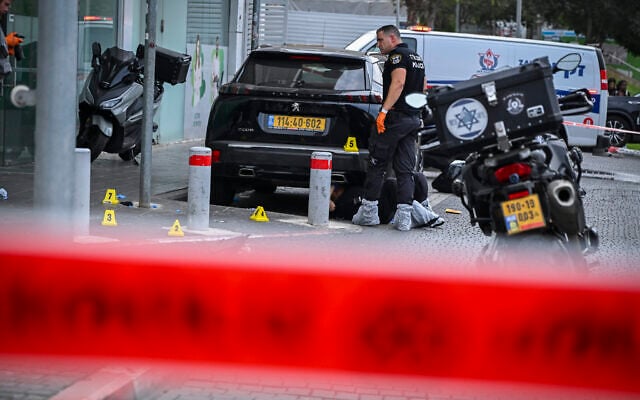 Police and forensic investigators at the scene of a fatal shooting outside a bank on Moshe Dayan Street in Tel Aviv, where two brothers were found shot dead after apparently shooting at each other, October 26, 2026. (Avshalom Sassoni/Flash90)