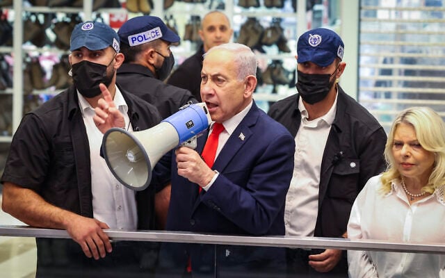 Prime Minister Benjamin Netanyahu, center, and his wife, Sara Netanyahu, try to mobilize supporters in Beit Shemesh in the final hours of voting in the Knesset election, October 27, 2026. (Yaakov Lederman/Flash90)