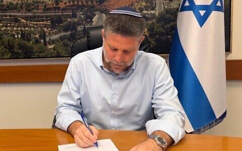 Finance Minister Bezalel Smotrich signs an order to reduce the excise tax on gasoline to bring down fuel prices at the pump, October 5, 2026. (X/Bezalel Smotrich)