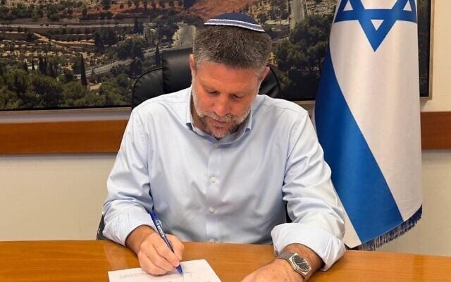 Finance Minister Bezalel Smotrich signs an order to reduce the excise tax on gasoline to bring down fuel prices at the pump, October 5, 2026. (X/Bezalel Smotrich)