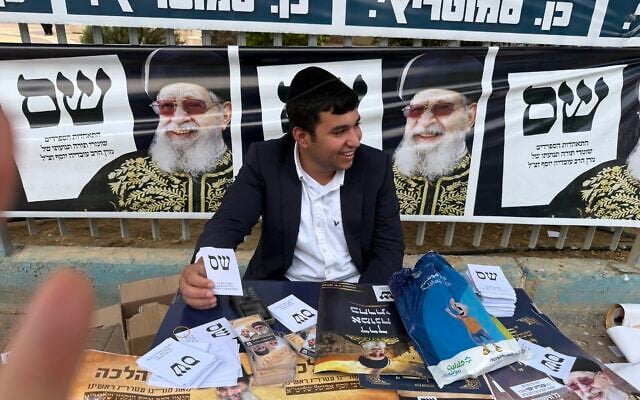 Yosef Levy hands out tickets and charms at a Shas stall outside a polling station in Ofakim, a right-wing religious stronghold hold in southern Israel, October 27, 2026. (Sue Surkes/Times of Israel) Yosef Levy hands out tickets and charms at a Shas stall outside a polling station in Ofakim, a right-wing religious stronghold hold in southern Israel, October 27, 2026. (Sue Surkes/Times of Israel)