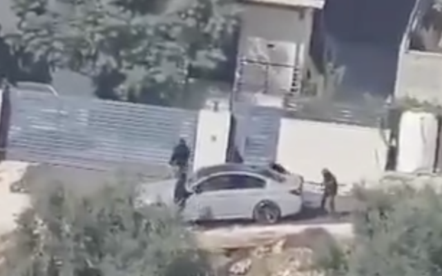 People identified as settlers are filmed smashing a car in the Palestinian town of Osarin, near Nablus, on October 3, 2023. (Screen capture: X, used in accordance with Clause 27a of the Copyright Law)