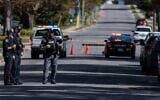A forensics officer points towards a police vehicle at the scene of a shooting the Sons of Jacob Synagogue. (Nick Lachance/Toronto Star via JTA)