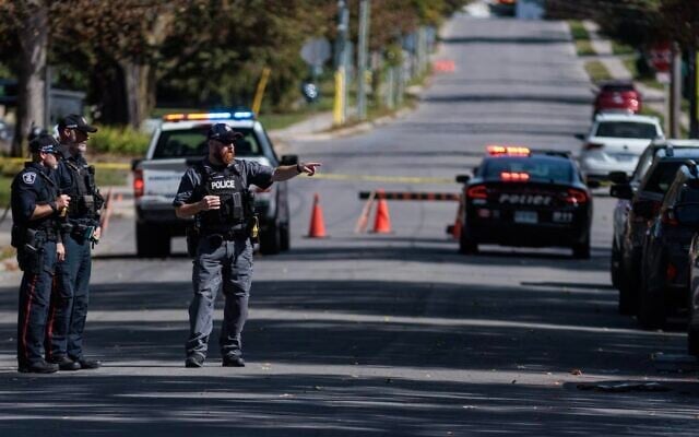 A forensics officer points towards a police vehicle at the scene of a shooting the Sons of Jacob Synagogue. (Nick Lachance/Toronto Star via JTA) A forensics officer points towards a police vehicle at the scene of a shooting the Sons of Jacob Synagogue. (Nick Lachance/Toronto Star via JTA)