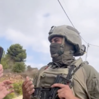 A masked soldier confronts an activist with Rabbis for Human Rights during the olive harvest season near Birzeit, close to Ramallah in the central West Bank, on October 9, 2026. (Screen capture: X/Rabbis for Human Rights)