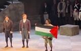 Opera singer Gabriel Sanchez-Ortega holds up a Palestinian flag during the curtain call of the opening night of "Tosca" at the Calgary Opera, in a still taken from a video posted by Sanchez-Ortega on Instagram, on October 16, 2026. (Screenshot/Gabriel Sanchez-Ortega via Instagram)