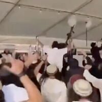 Settler extremists hoists weapons up in the air while dancing at a wedding in the Gush Etzion area of the West Bank in October 2026. (Screen capture/X)