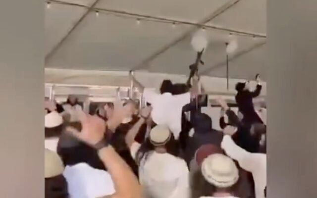 Settler extremists hoists weapons up in the air while dancing at a wedding in the Gush Etzion area of the West Bank in October 2026. (Screen capture/X)