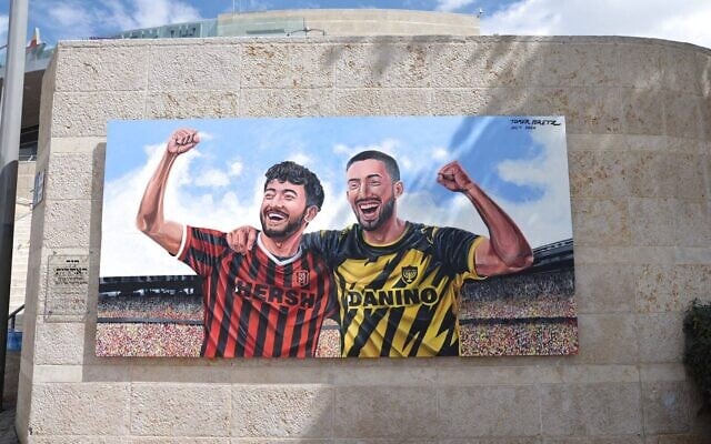 A mural by artist Tomer Peretz, portraying Hersh Goldberg-Polin, left, and Ori Danino, right, in their team shirts, is unveiled at Jerusalem's Teddy Stadium by the municipality on October 5, 2026 (Courtesy) A mural by artist Tomer Peretz, portraying Hersh Goldberg-Polin, left, and Ori Danino, right, in their team shirts, is unveiled at Jerusalem's Teddy Stadium by the municipality on October 5, 2026 (Courtesy)