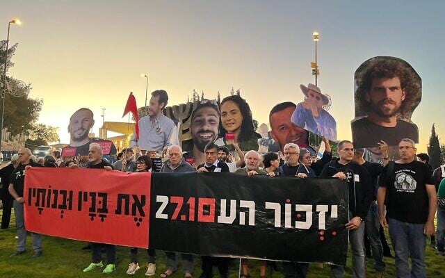 Protesters outside the Knesset mark the three year anniversary since October 7, 2023, with a banner reading 'The people shall remember their sons and daughters,' a reference to the memorial prayer, with a logo bringing together the dates of the onslaught and the upcoming election, in Jerusalem, October 7, 2026 (Orna Kupferman/Pro-democracy protest groups)