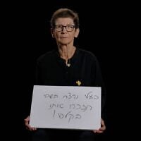 Former hostage Yocheved Lifshitz holds a sign intended to stir voters on Election Day, stating, "My husband was killed in captivity, remember him in the voting booth!" (Courtesy)