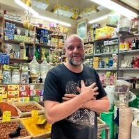 Shop vendor Jarjee stands in his stall at the bazaar in Acre on October 28, 2026. (Diana Bletter/Times of Israel)